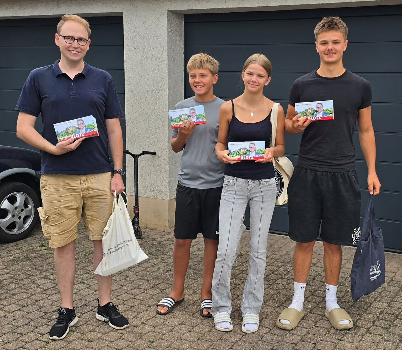 Man sieht Stephan Klotz mit seinen fleißigen Helfern beim Verteilen der Flyer.