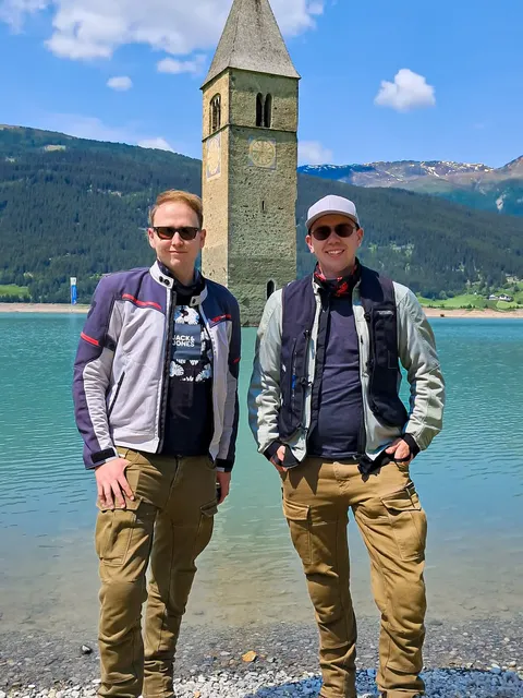 Stephan Klotz steht mit seinem Bruder Philipp Klotz bei einer Motorradtour am Reschensee.