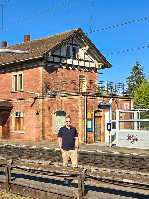 Stephan Klotz steht vor dem Bahnhof in Orschweier am Gleis.