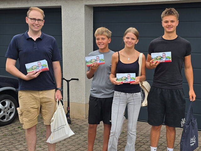 Man sieht Stephan Klotz mit seinen fleißigen Helfern beim Verteilen der Flyer.