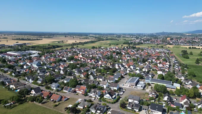Zu sehen ist ein Luftbild von Orschweier mit: Hansjakob-Schule SBBZ, Mehrzweckhalle, Ortsverwaltung, Malaucèner Platz, Gewerbegebiet & Bahnhof.