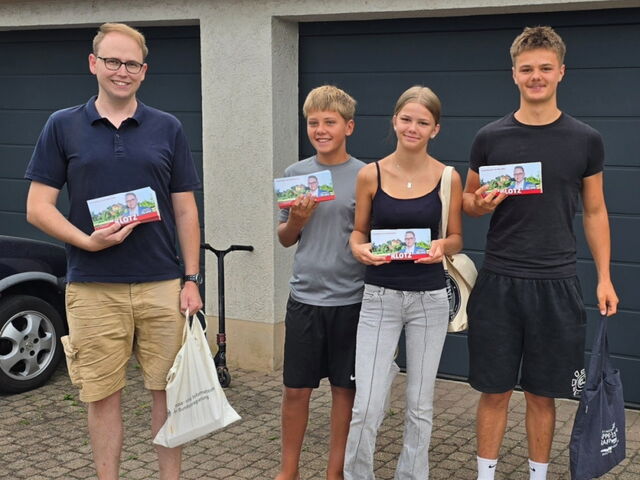 Man sieht Stephan Klotz mit seinen fleißigen Helfern beim Verteilen der Flyer.